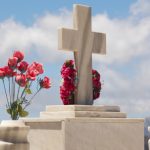 An image of tembstones decorated with colorful roses.