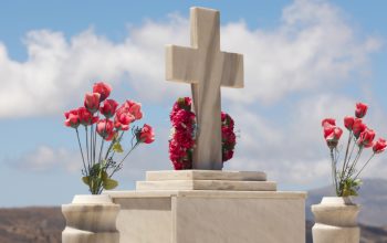 An image of tembstones decorated with colorful roses.