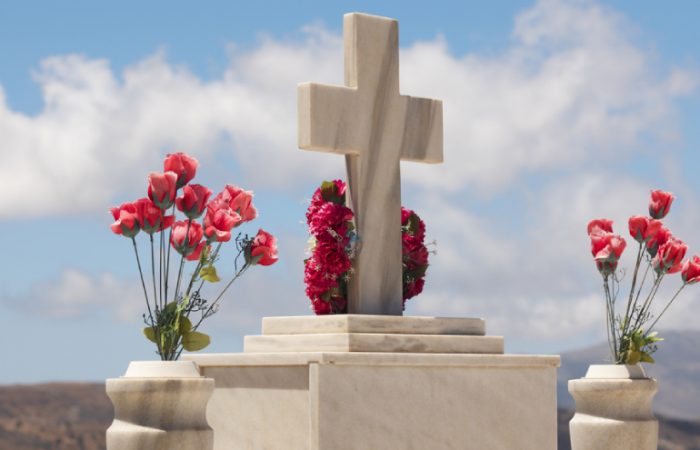 An image of tembstones decorated with colorful roses.