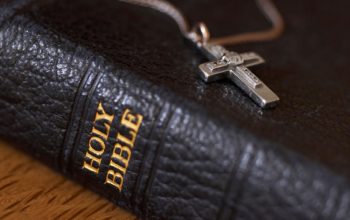 An Image of Holy Bible with cross dollar.