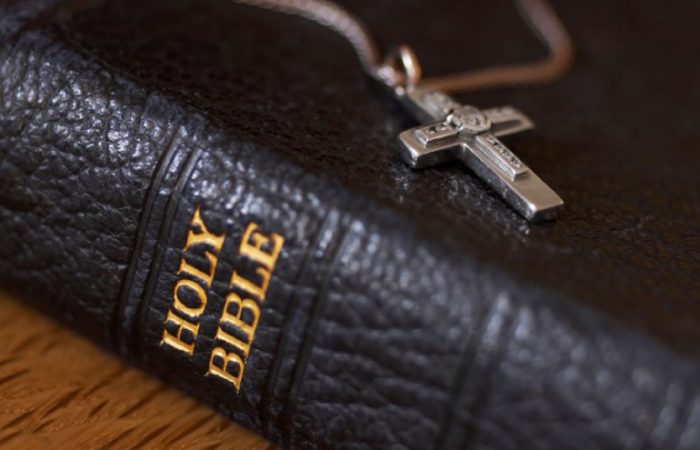 An Image of Holy Bible with cross dollar.